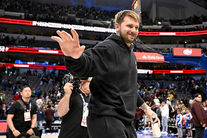 Luka Doncic saluda al público en las gradas vistiendo pants negros